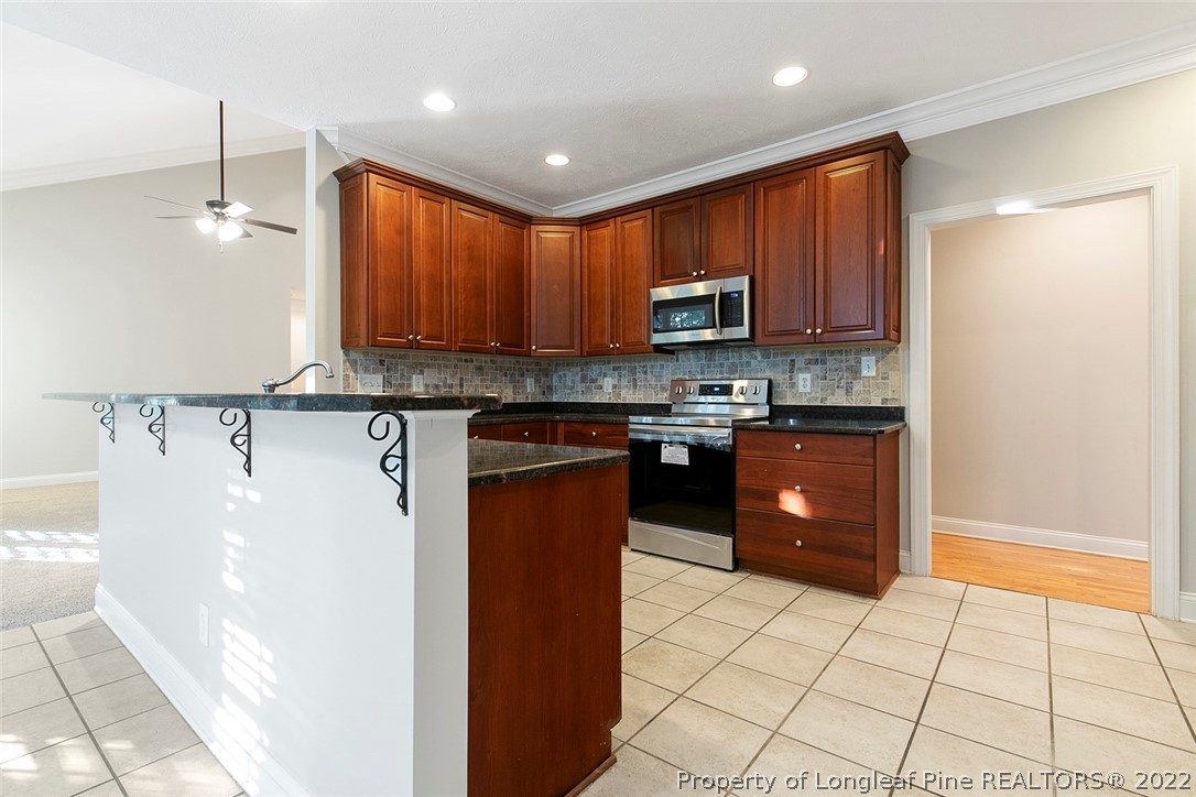 480 Whispering Pines Drive Spring Lake, NC 28390 - Photo 17 of 48 a kitchen with stainless steel appliances granite countertop a stove a sink and a refrigerator
