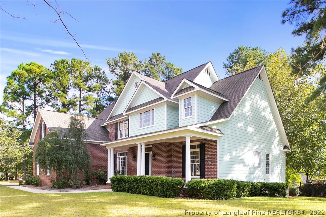 480 Whispering Pines Drive Spring Lake, NC 28390 - Photo 2 of 48 a front view of a house with a garden and trees