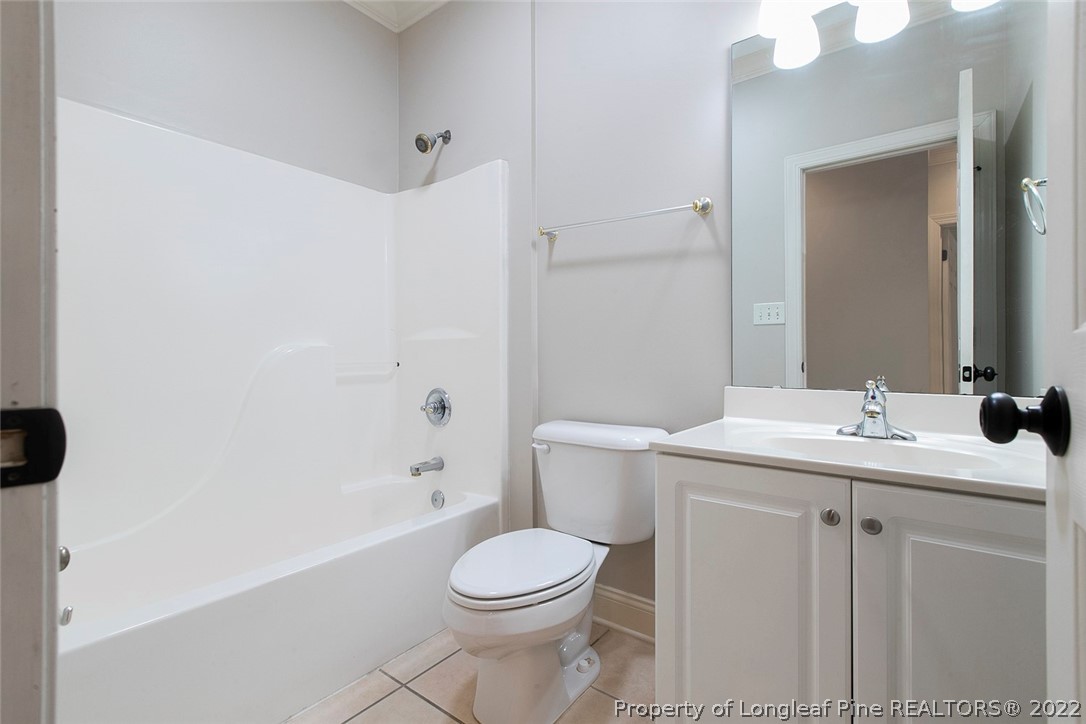 480 Whispering Pines Drive Spring Lake, NC 28390 - Photo 21 of 48 a bathroom with a granite countertop toilet sink and mirror