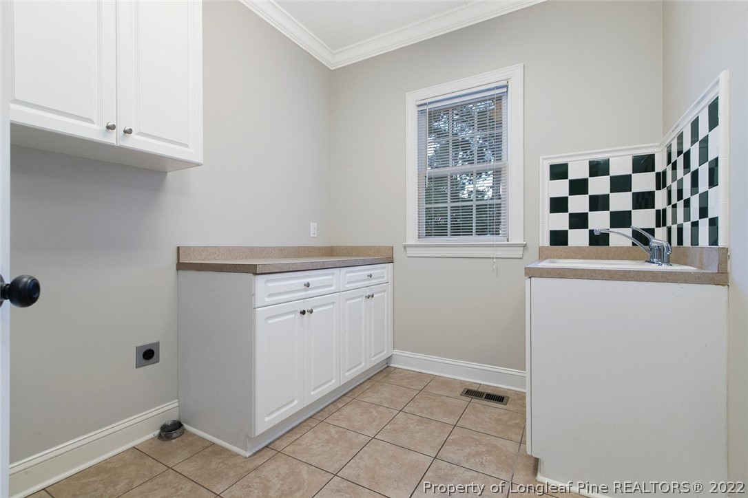 480 Whispering Pines Drive Spring Lake, NC 28390 - Photo 22 of 48 a view of a kitchen with white cabinets