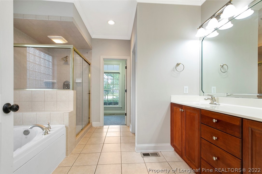 480 Whispering Pines Drive Spring Lake, NC 28390 - Photo 27 of 48 a spacious bathroom with a bathtub shower sink vanity and mirror