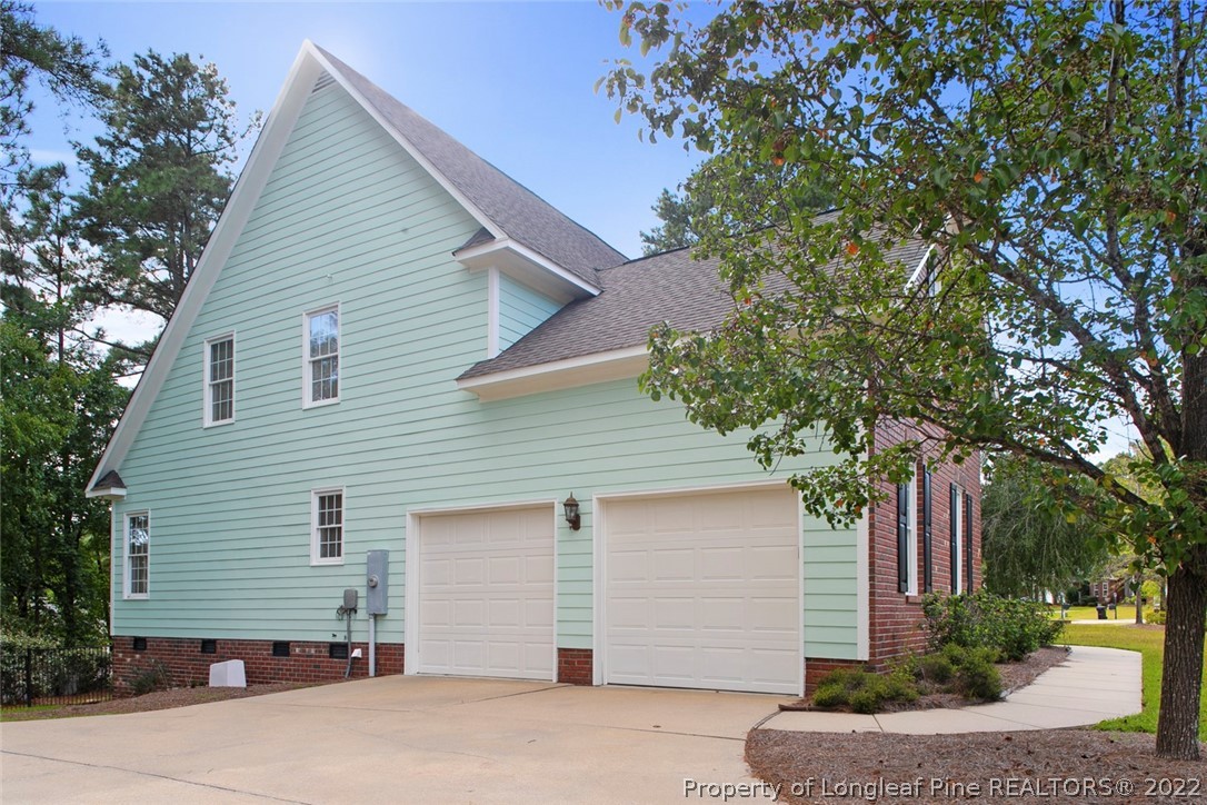 480 Whispering Pines Drive Spring Lake, NC 28390 - Photo 48 of 48 a view of a white house with a tree and wooden fence
