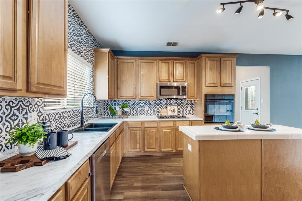 1445 Berkley Road Allen, TX 75002 - Photo 9 of 30 Your family's chef will appreciate a gas cook top, built-in wall oven, built-in stainless steel microwave, and high-neck faucet.