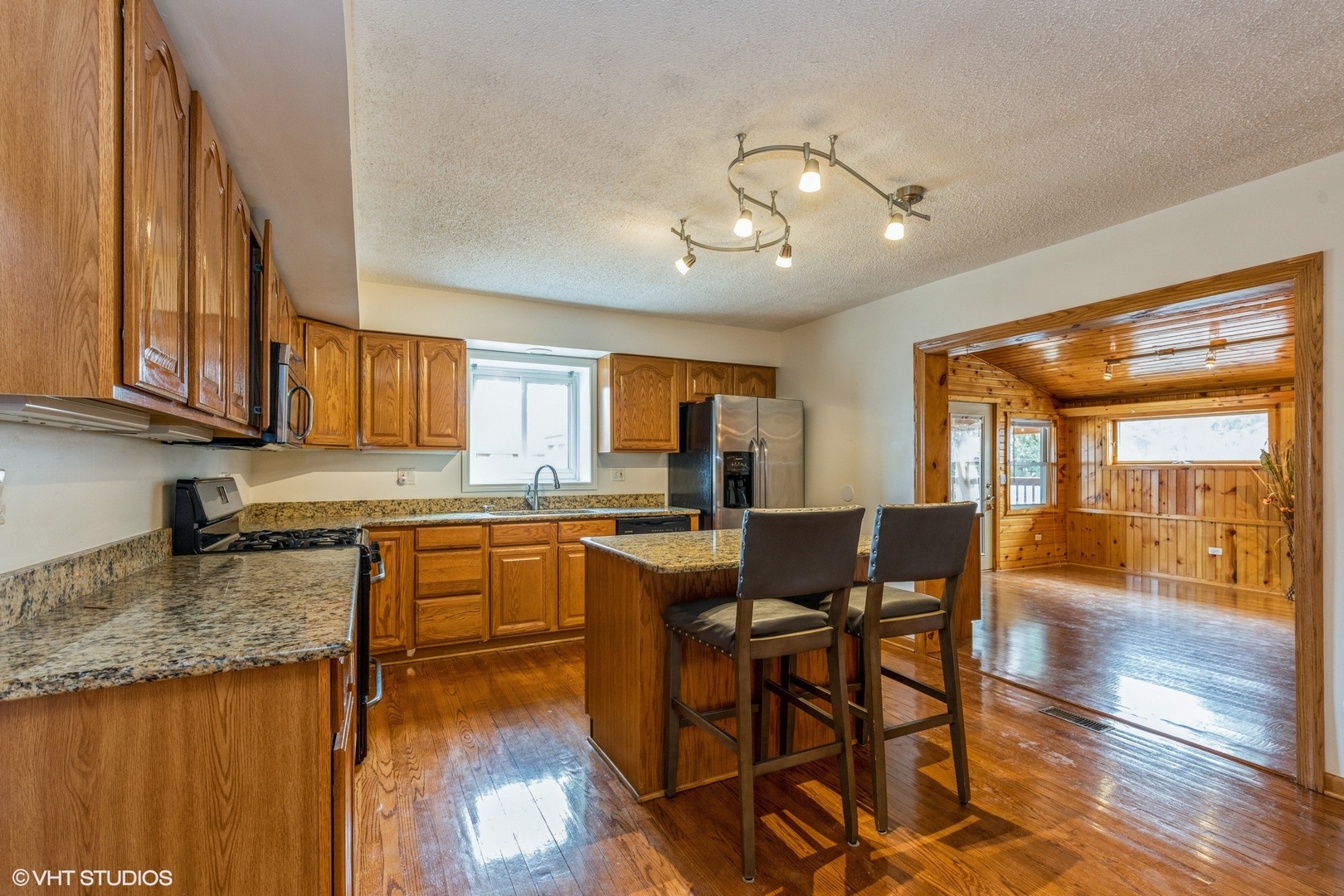 329 Killdeer Road Bloomingdale, IL 60108 - Photo 8 of 31 a kitchen with stainless steel appliances granite countertop wooden cabinets a dining table and chairs