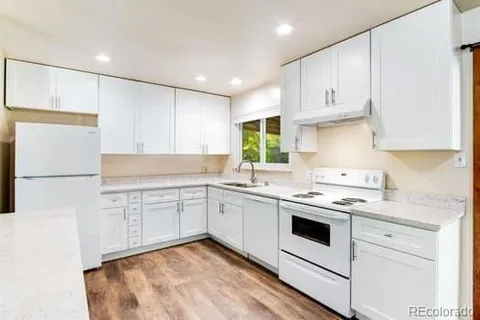 a kitchen with a white cabinets and white appliances