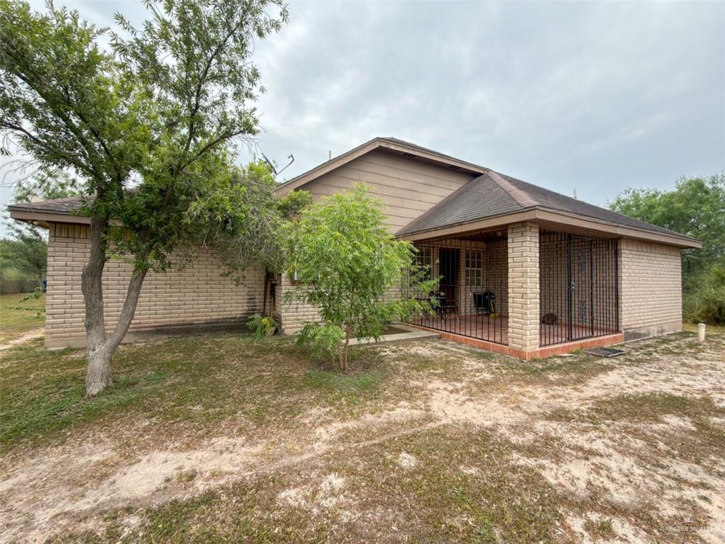 7435 Dillon Road Donna, TX 78537 - Photo 10 of 17 Brick exterior featuring a screened porch with a tiled floor