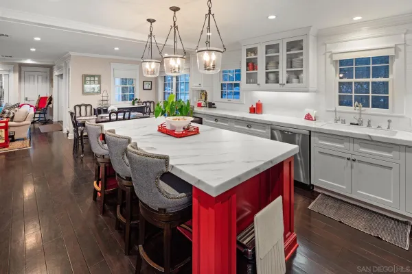 a kitchen with stainless steel appliances granite countertop a stove a sink dishwasher and a dining table with wooden floor