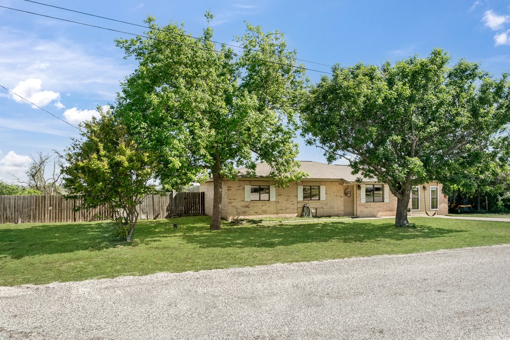 90 Quail Run Harper, TX 78631 - Photo 23 of 25 a front view of a house with a garden and trees