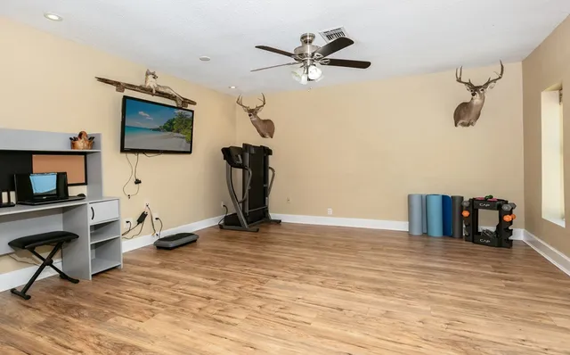 a view of a room with gym equipment and a flat screen tv