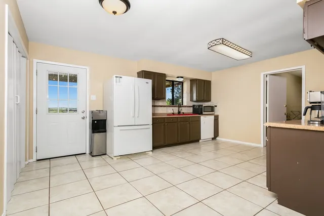 a kitchen with a refrigerator a sink dishwasher and a oven with wooden floor