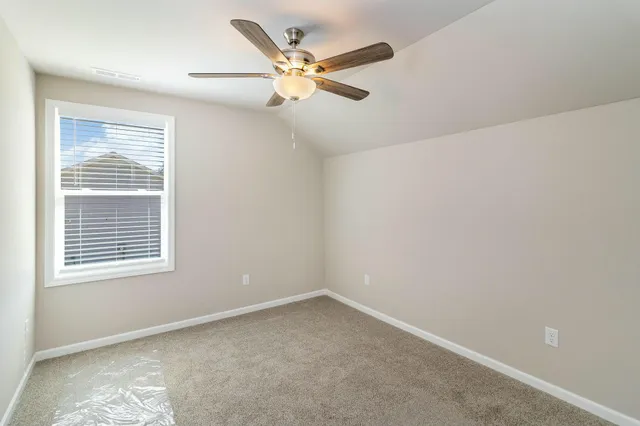 an empty room with a window and a ceiling fan