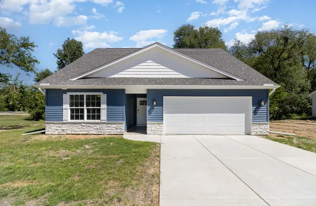 a front view of a house with a yard and garage