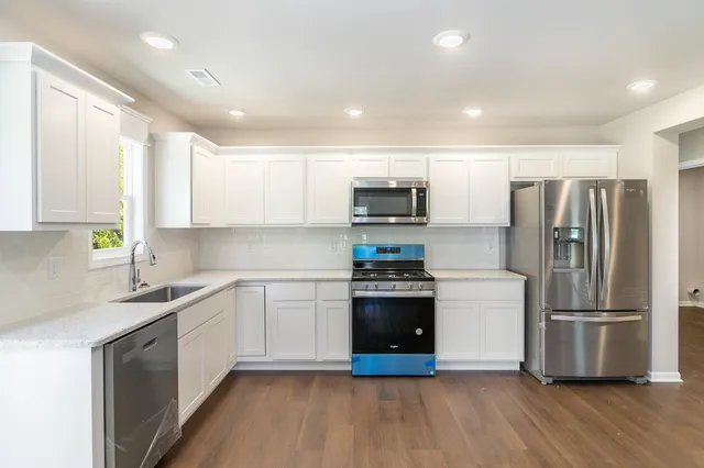 a kitchen with a sink a refrigerator a microwave and cabinets