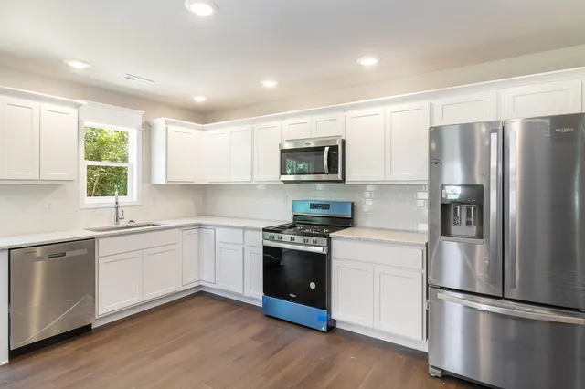 a kitchen with stainless steel appliances a refrigerator sink and microwave