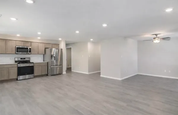 a view of kitchen with stainless steel appliances a refrigerator and a stove top oven