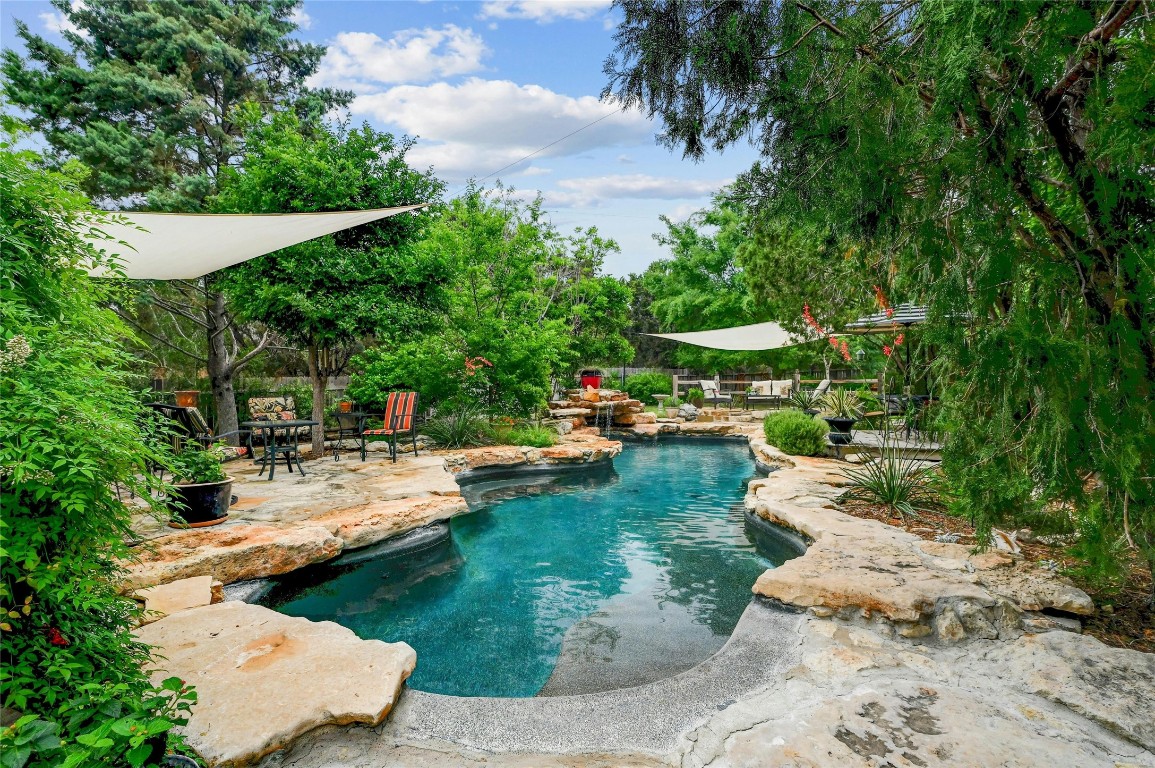 This lagoon styled pool has a live edge surround, waterfall and easy slope ramp to enter the pool.