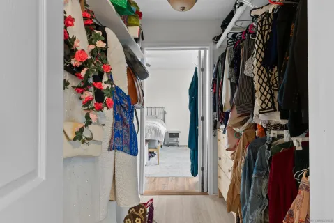 a view of walk in closet with clothes and shoes
