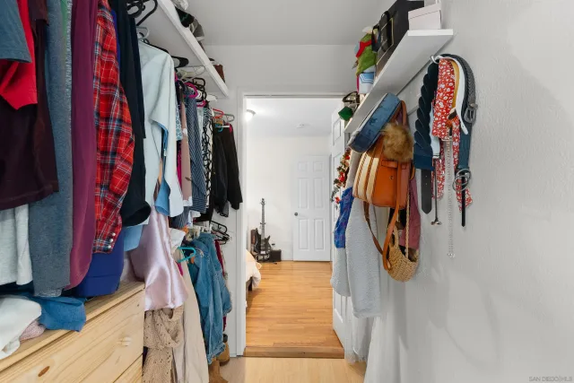 a view of walk in closet with clothes and shoes