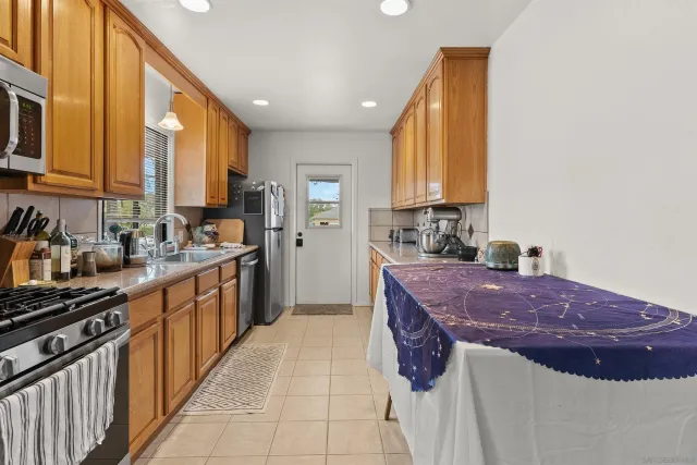 a kitchen with stainless steel appliances a sink stove and cabinets