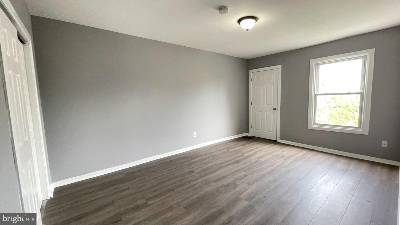 1340 West 7th Street Chester, PA 19013 - Photo 11 of 26 an empty room with wooden floor and windows