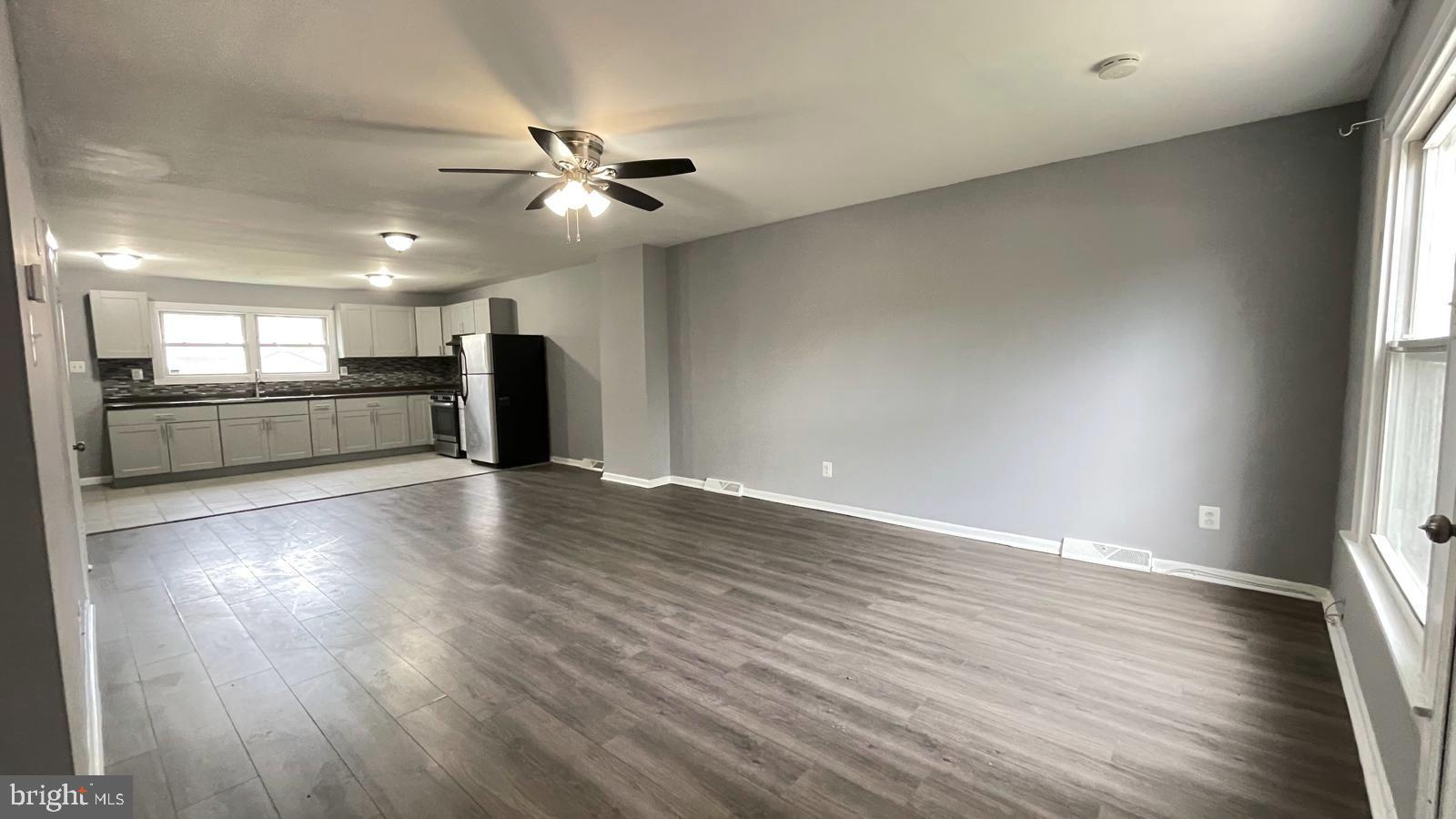 1340 West 7th Street Chester, PA 19013 - Photo 20 of 26 an empty room with wooden floor a ceiling fan and windows