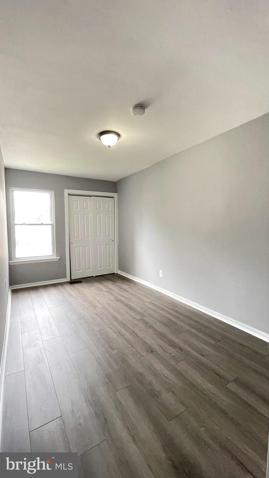 1340 West 7th Street Chester, PA 19013 - Photo 9 of 26 an empty room with wooden floor and windows