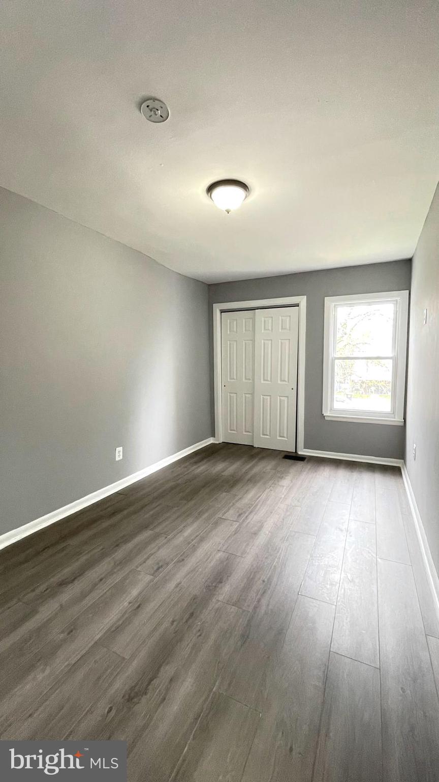 1340 West 7th Street Chester, PA 19013 - Photo 10 of 26 an empty room with wooden floor and windows