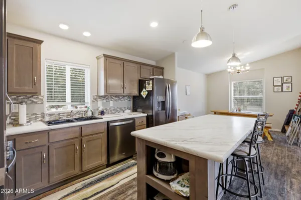 a kitchen with kitchen island a refrigerator stove microwave and cabinets