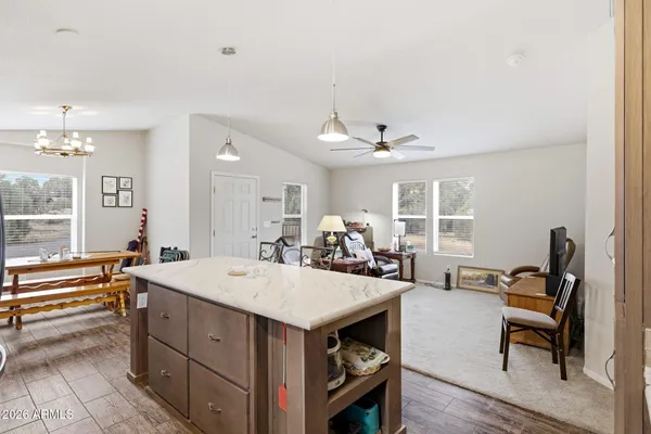 a kitchen with stainless steel appliances granite countertop a kitchen island hardwood floor sink stove dining table and chairs