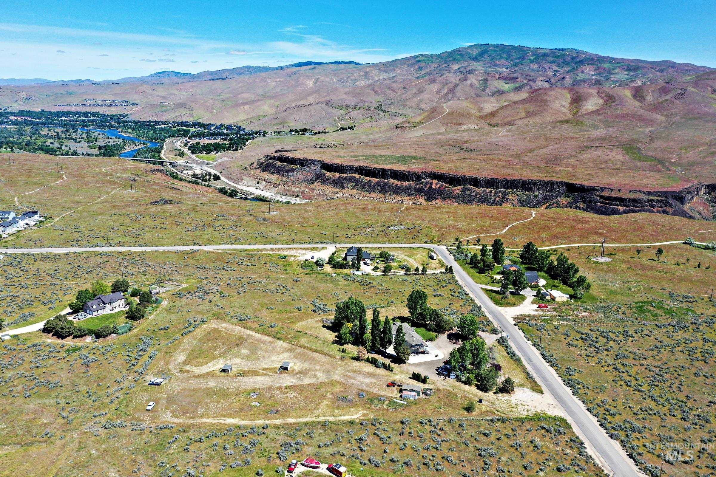 7213 East Columbia Road Boise, ID 83716 - Photo 43 of 47 Expansive rural setting featuring a distant river, a prominent mountain backdrop, and multiple single-family homes