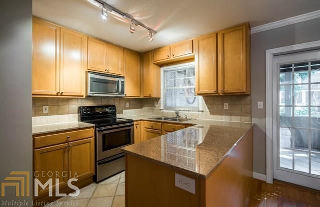 1101 Collier Street Northwest, Unit R1 Atlanta, GA 30318 - Photo 1 of 1 Open kitchen featuring granite counter tops and stained cabinets