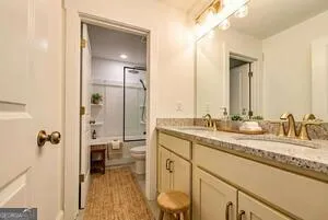 a en suite bathroom with a granite countertop sink mirror and double