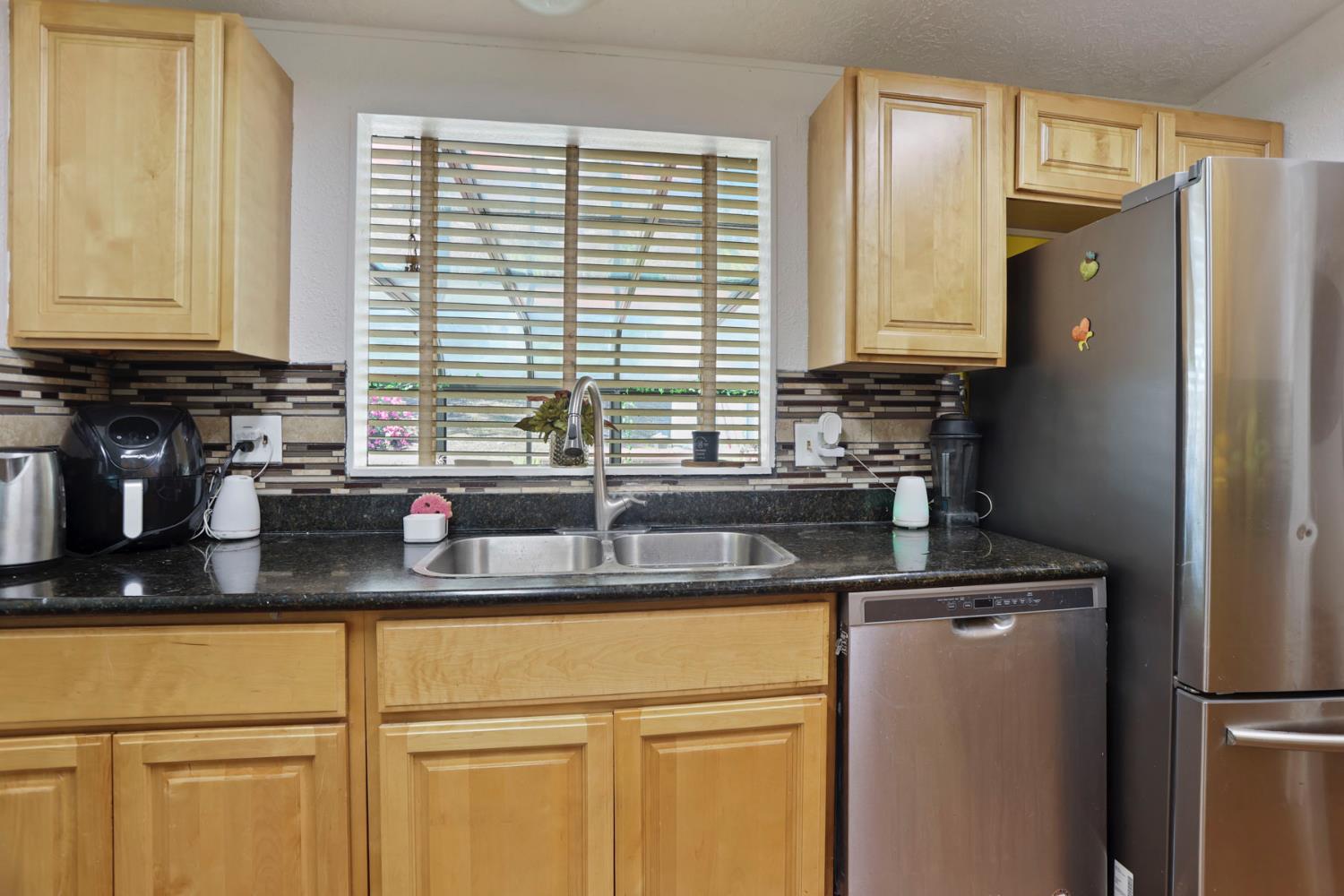 901 Quail Oaks Road Valley Springs, CA 95252 - Photo 12 of 59 a kitchen with stainless steel appliances granite countertop a sink a refrigerator and a granite counter tops
