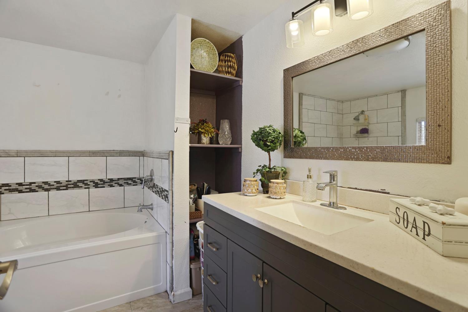 901 Quail Oaks Road Valley Springs, CA 95252 - Photo 19 of 59 a bathroom with a bathtub sink and mirror