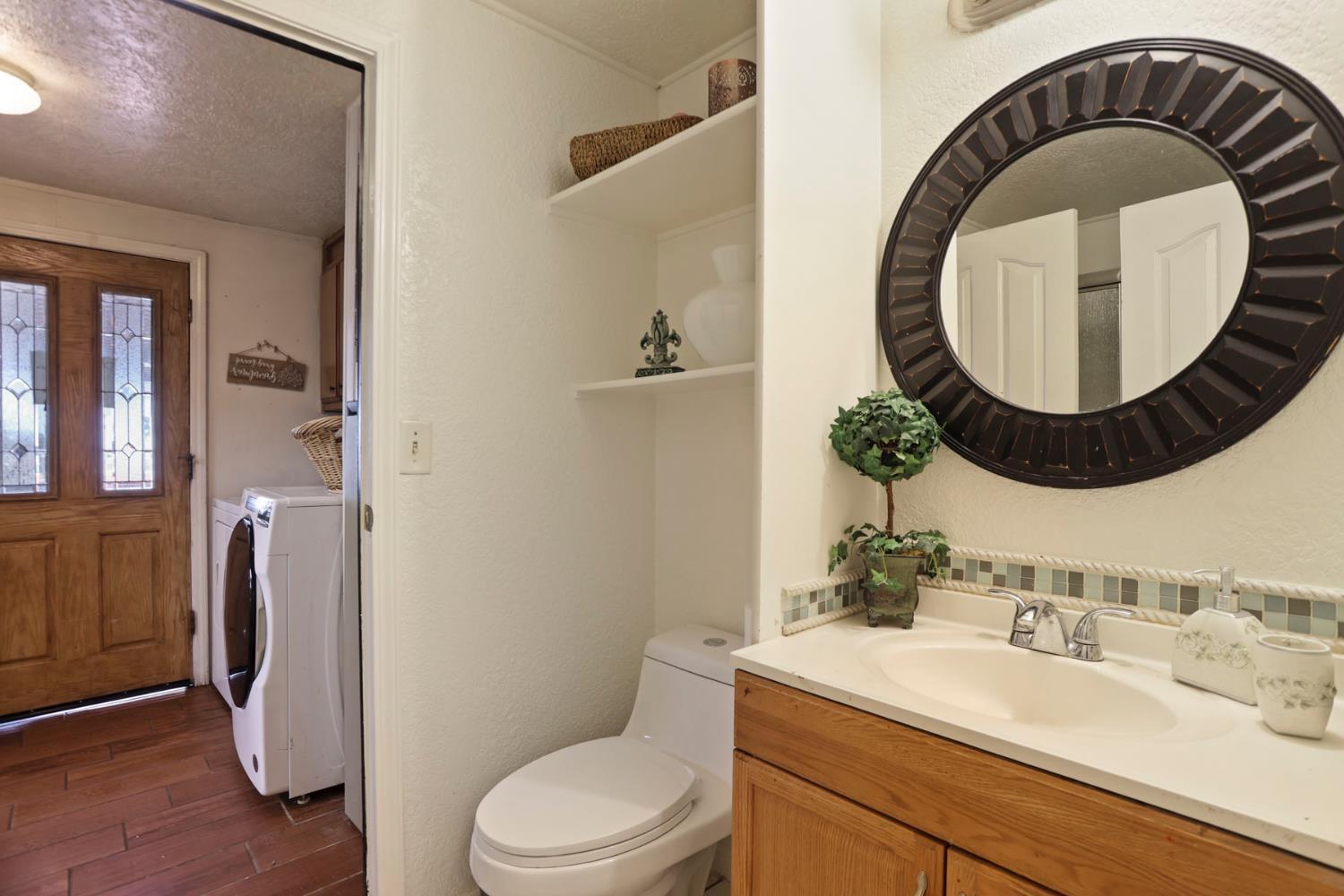 901 Quail Oaks Road Valley Springs, CA 95252 - Photo 24 of 59 a bathroom with a toilet a sink and a mirror