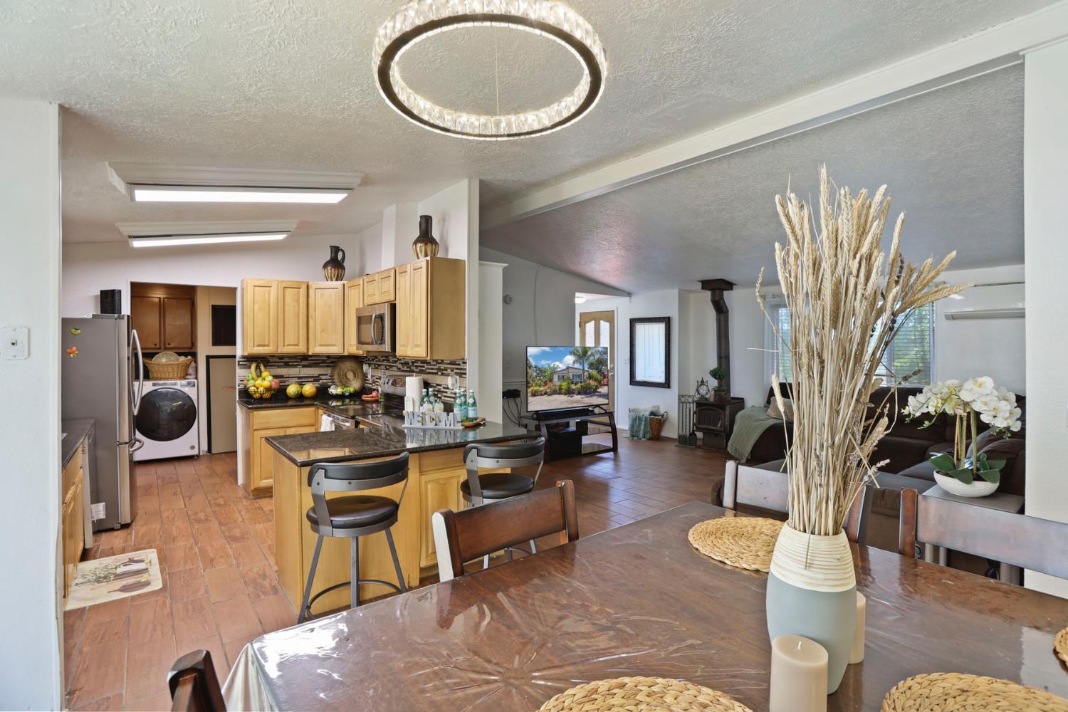 901 Quail Oaks Road Valley Springs, CA 95252 - Photo 9 of 59 a living room with furniture a dining table and a fireplace