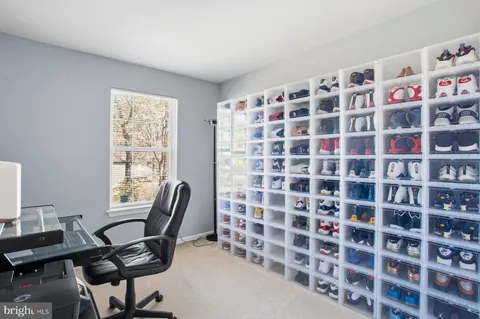 a view of a workspace with furniture and a window