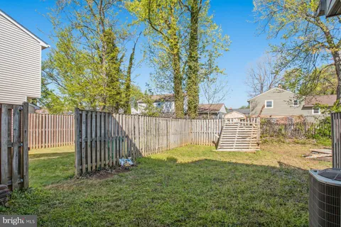 a view of a garden with wooden fence and trees