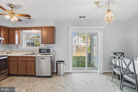 a kitchen with stainless steel appliances granite countertop a stove a sink dishwasher and a refrigerator with wooden floor