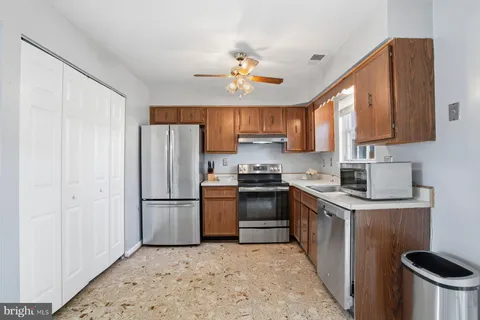 a kitchen with stainless steel appliances granite countertop a refrigerator a stove top oven a sink and dishwasher