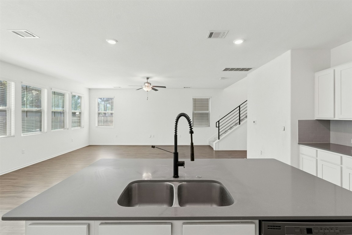 10405 Tree Duck Drive Austin, TX 78748 - Photo 32 of 33 Kitchen featuring white cabinets, open floor plan, a center island with sink, dark stone countertops, and recessed lighting
