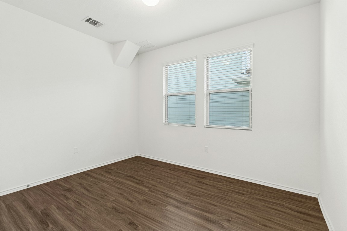 10405 Tree Duck Drive Austin, TX 78748 - Photo 12 of 33 Unfurnished room featuring dark wood-type flooring and baseboards