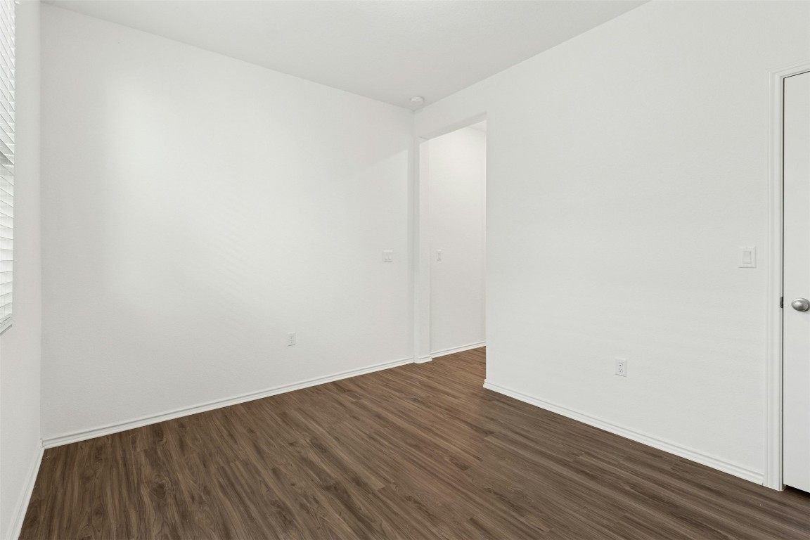 10405 Tree Duck Drive Austin, TX 78748 - Photo 13 of 33 Unfurnished room with dark wood-style flooring and baseboards