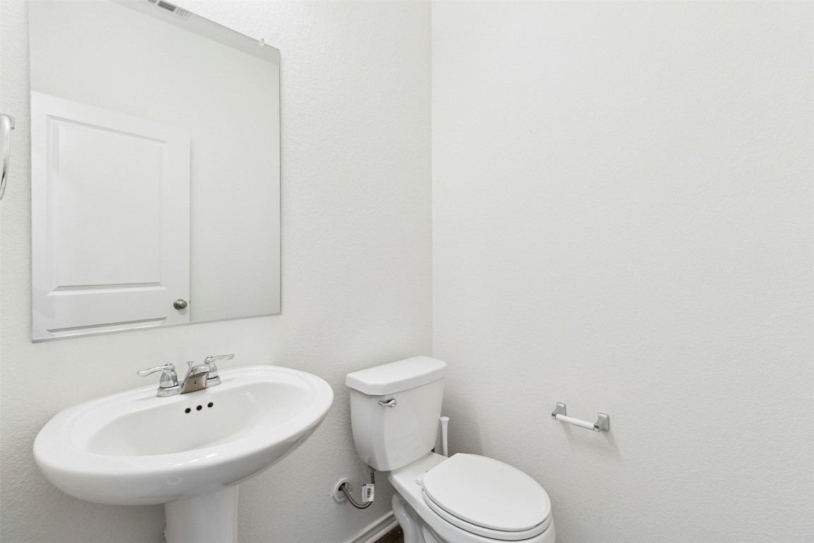10405 Tree Duck Drive Austin, TX 78748 - Photo 14 of 33 Half bathroom featuring toilet and a textured wall