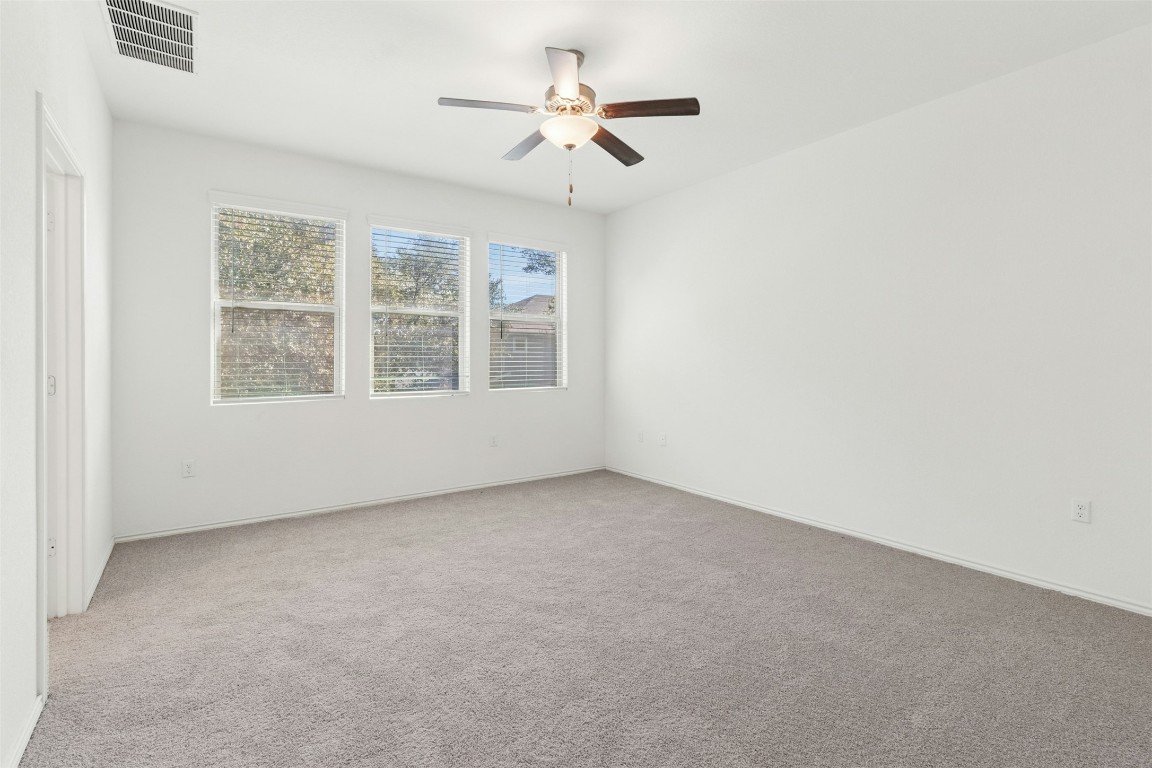 10405 Tree Duck Drive Austin, TX 78748 - Photo 15 of 33 Empty room with light colored carpet and a ceiling fan