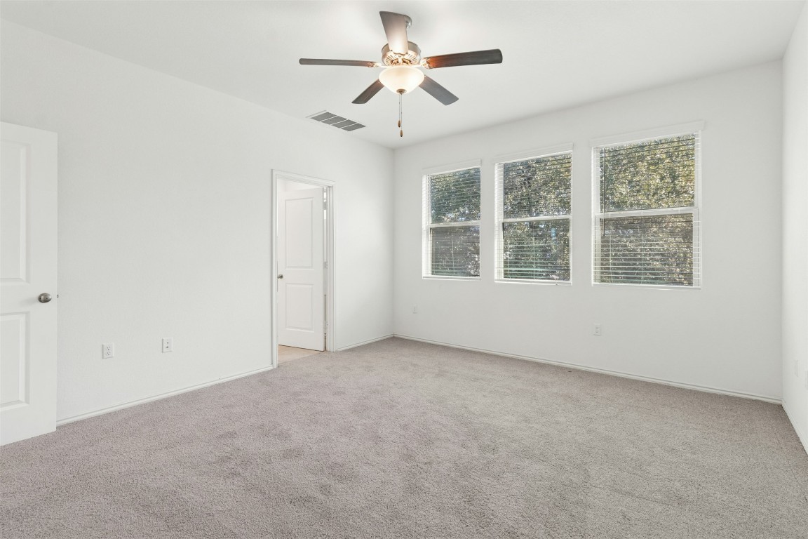 10405 Tree Duck Drive Austin, TX 78748 - Photo 16 of 33 Empty room with light colored carpet and a ceiling fan
