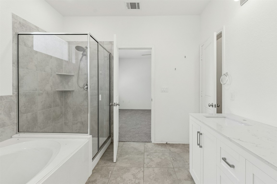 10405 Tree Duck Drive Austin, TX 78748 - Photo 19 of 33 Full bathroom with a stall shower, a bath, and vanity