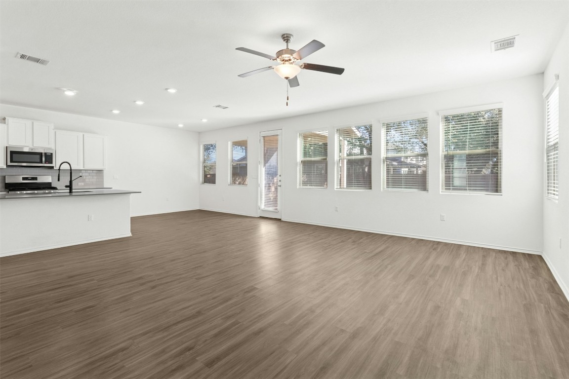 10405 Tree Duck Drive Austin, TX 78748 - Photo 5 of 33 Unfurnished living room featuring dark wood-style floors, a ceiling fan, and recessed lighting