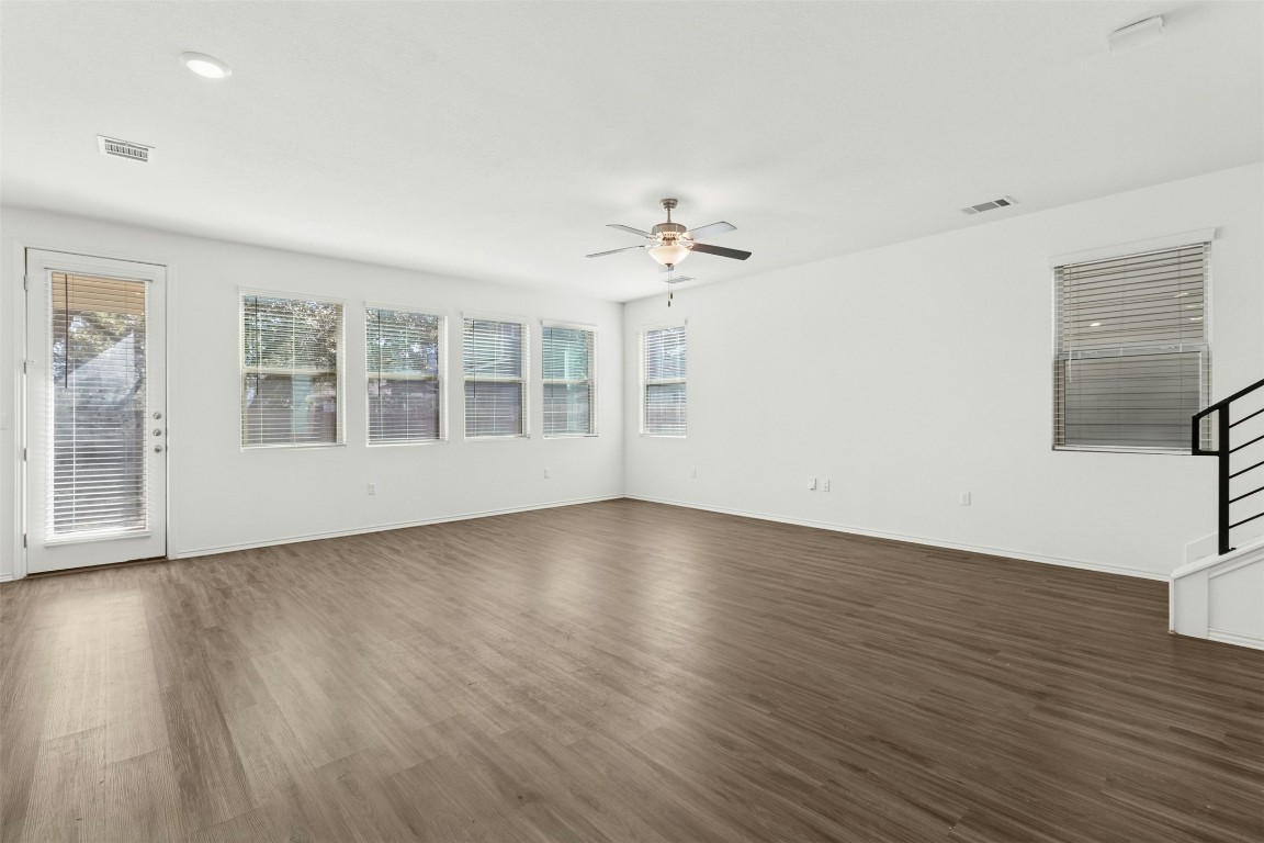 10405 Tree Duck Drive Austin, TX 78748 - Photo 6 of 33 Unfurnished room with dark wood finished floors, a ceiling fan, and stairway