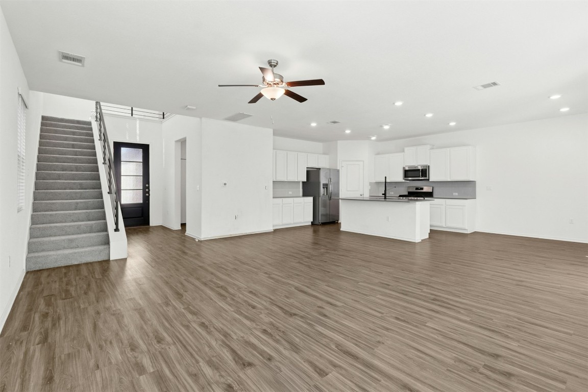 10405 Tree Duck Drive Austin, TX 78748 - Photo 7 of 33 Unfurnished living room with stairway, dark wood-style floors, a ceiling fan, and recessed lighting